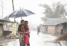 A Manipuri couple riding a bicycle on a rainy day!